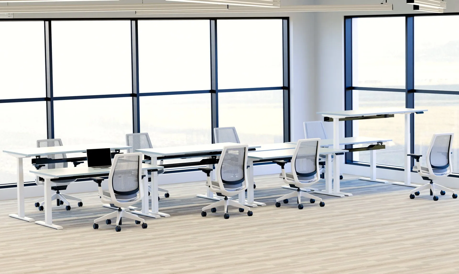 R!se sit-stand desks deployed across a bright modern London office workspace